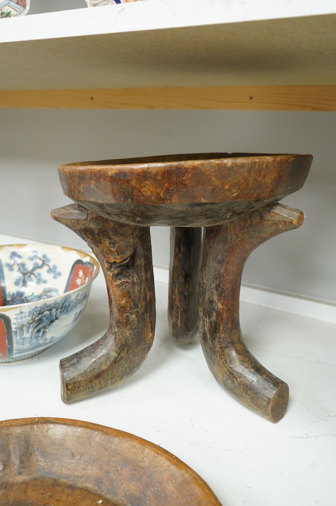 An Ethiopian tribal three footed stool and a carved handled bowl, stool 33cm high